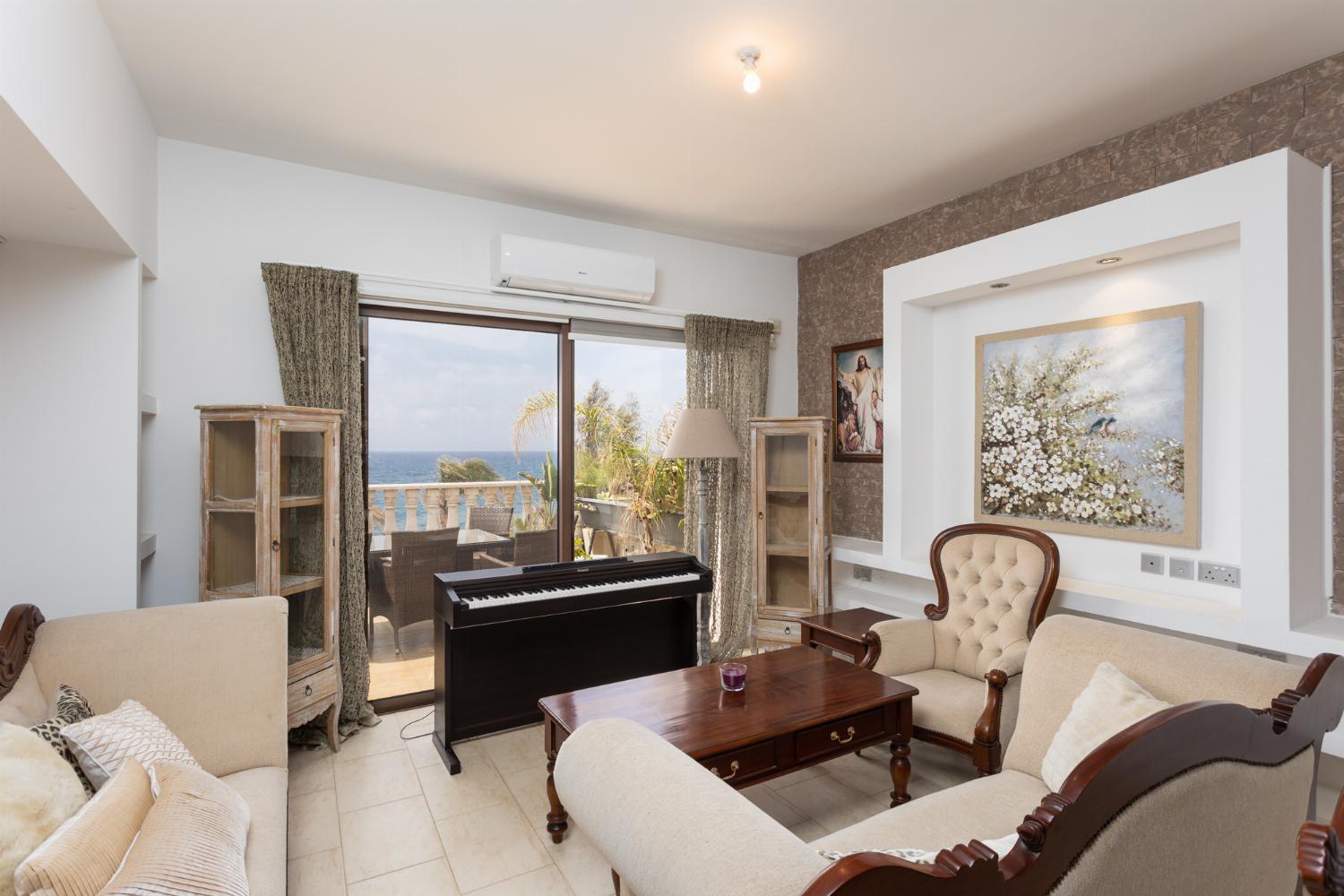 Main building: living room with sofas, dining area, A/C, WiFi internet, and sea views