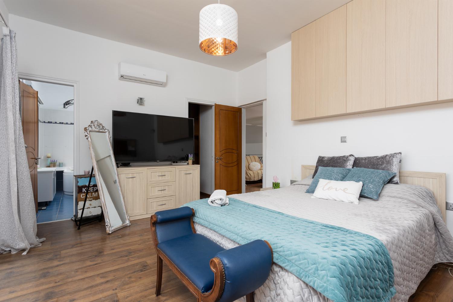 Main building: double bedroom with en suite bathroom, A/C, TV, walk-in wardrobe, and sea views