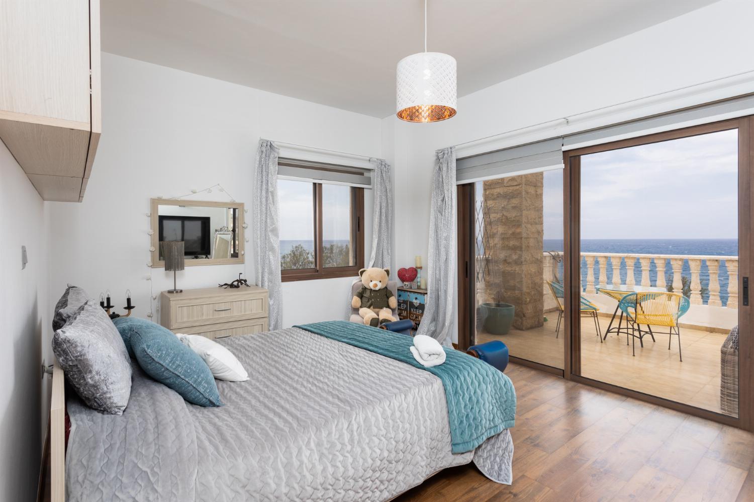Main building: double bedroom with en suite bathroom, A/C, TV, walk-in wardrobe, and sea views