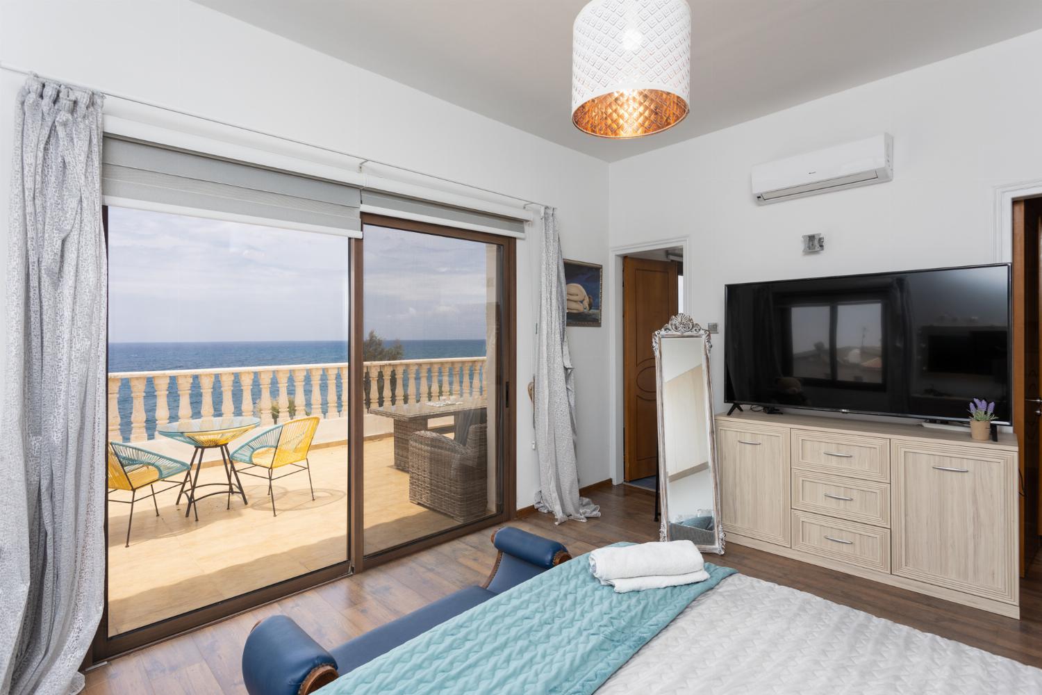 Main building: double bedroom with en suite bathroom, A/C, TV, walk-in wardrobe, and sea views