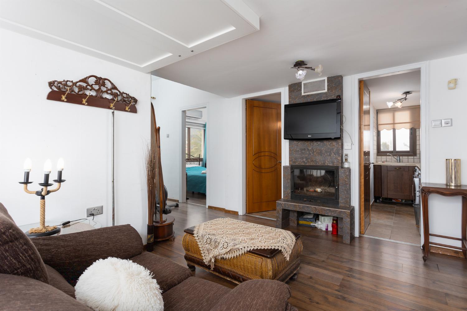 Main building: living area with sofa, ornamental fireplace, and TV