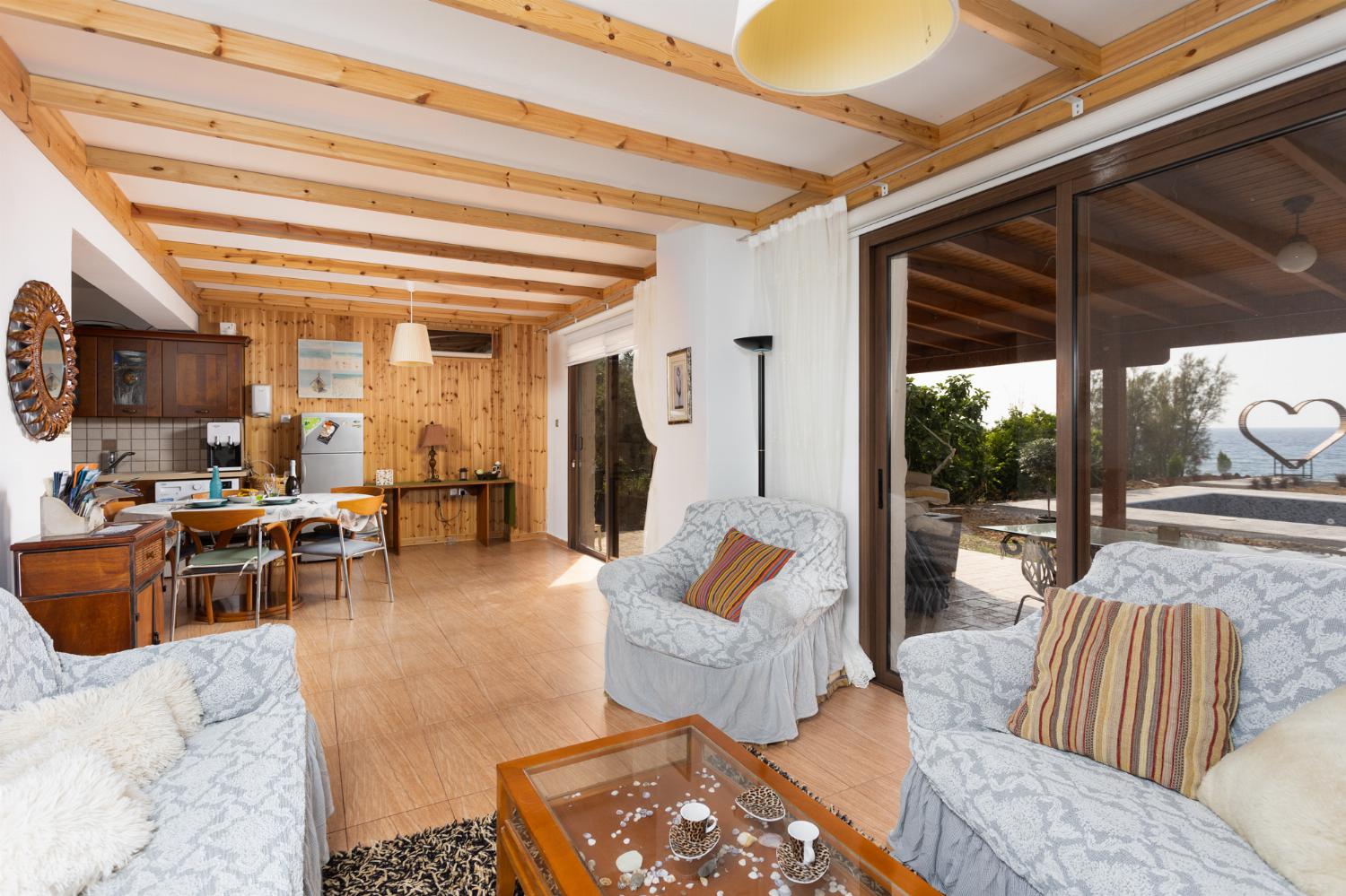 Front apartment: open-plan living room with sofas, dining area, kitchen, A/C, WiFi internet, satellite TV, and sea views