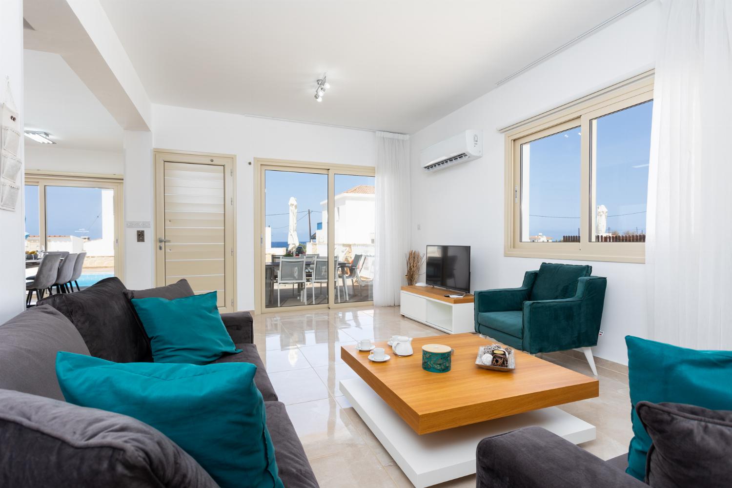 Open-plan living room with sofas, dining area, kitchen, A/C, WiFi internet, satellite TV, and sea views