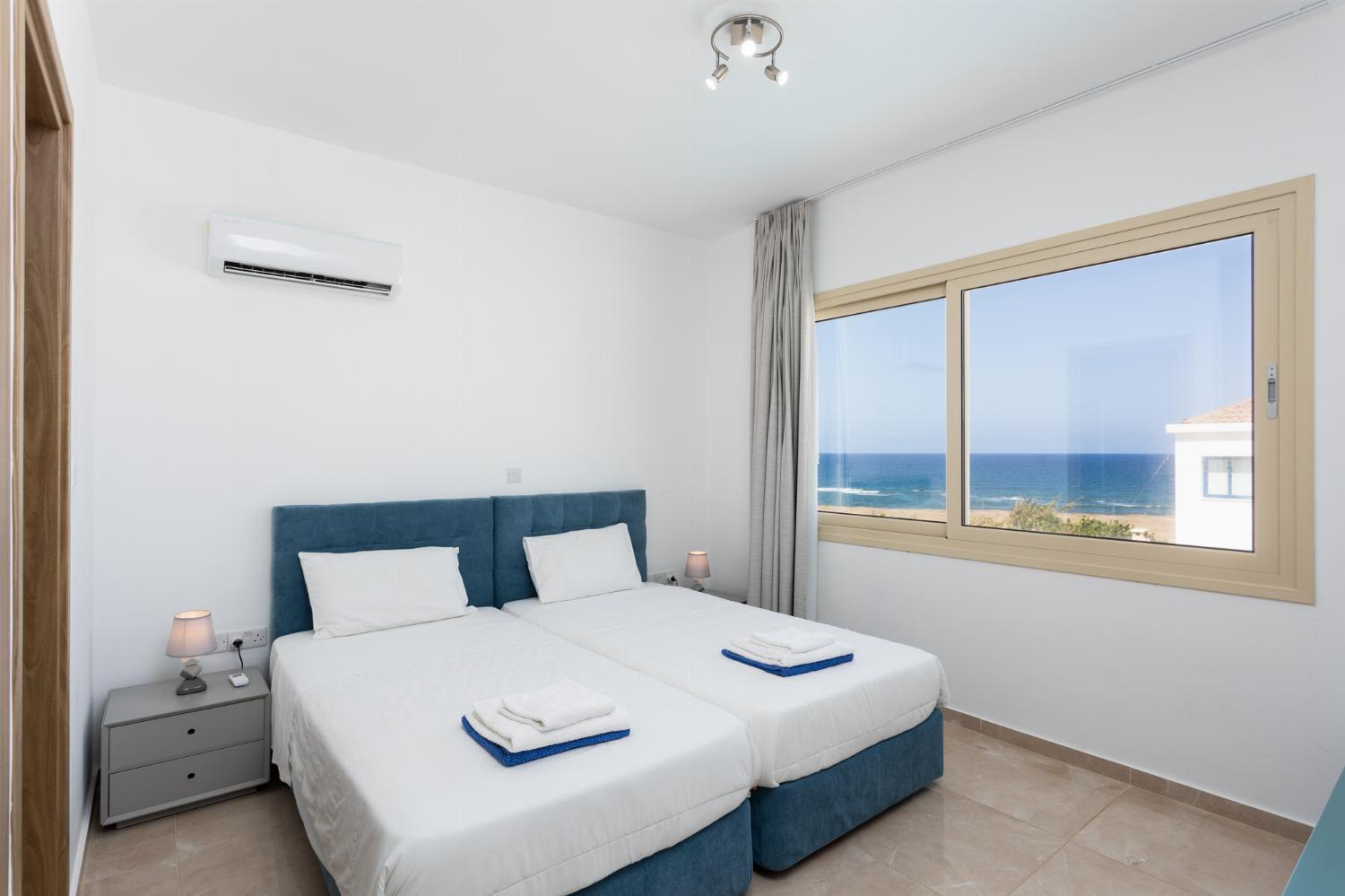 Twin bedroom with en suite bathroom, A/C, and sea views