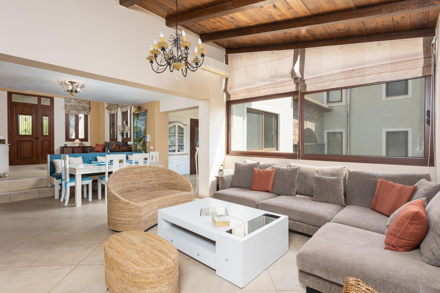 Open-plan living room with sofas, dining area, kitchen, mezzanine, ornamental fireplace, A/C, WiFi internet, and satellite TV