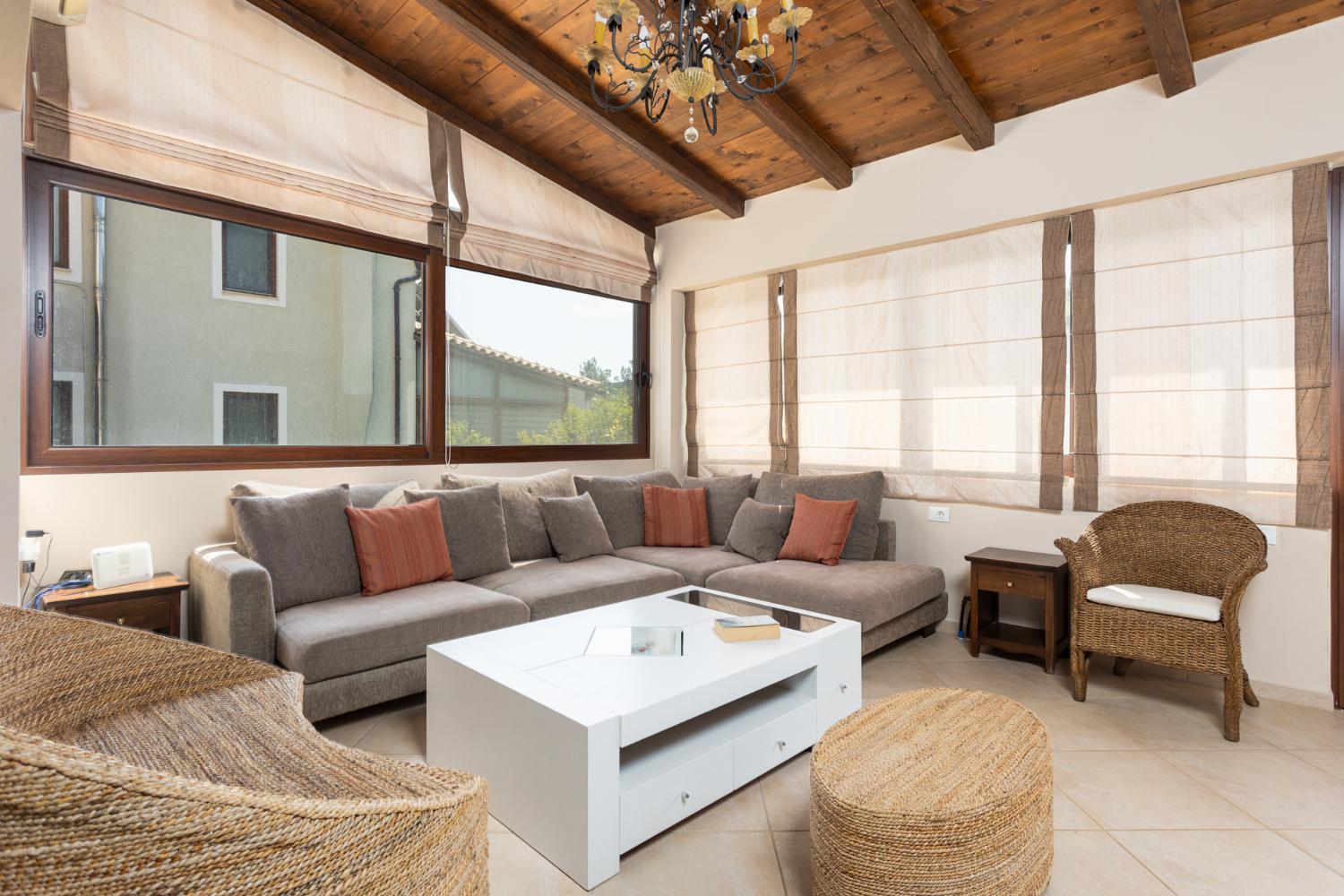 Open-plan living room with sofas, dining area, kitchen, mezzanine, ornamental fireplace, A/C, WiFi internet, and satellite TV