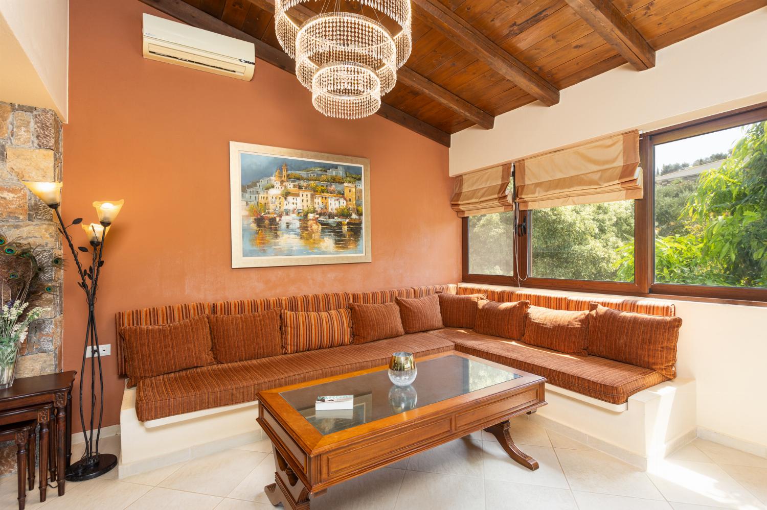 Open-plan living room with sofas, dining area, kitchen, ornamental fireplace, A/C, WiFi internet, and satellite TV