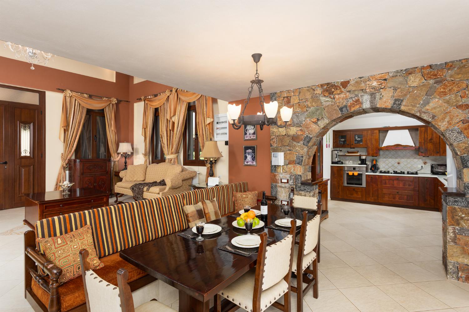 Open-plan living room with sofas, dining area, kitchen, ornamental fireplace, A/C, WiFi internet, and satellite TV
