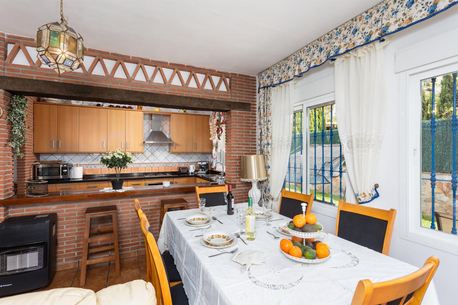 Open-plan living room with sofas, dining area, kitchen, ornamental fireplace, A/C, WiFi internet, and satellite TV