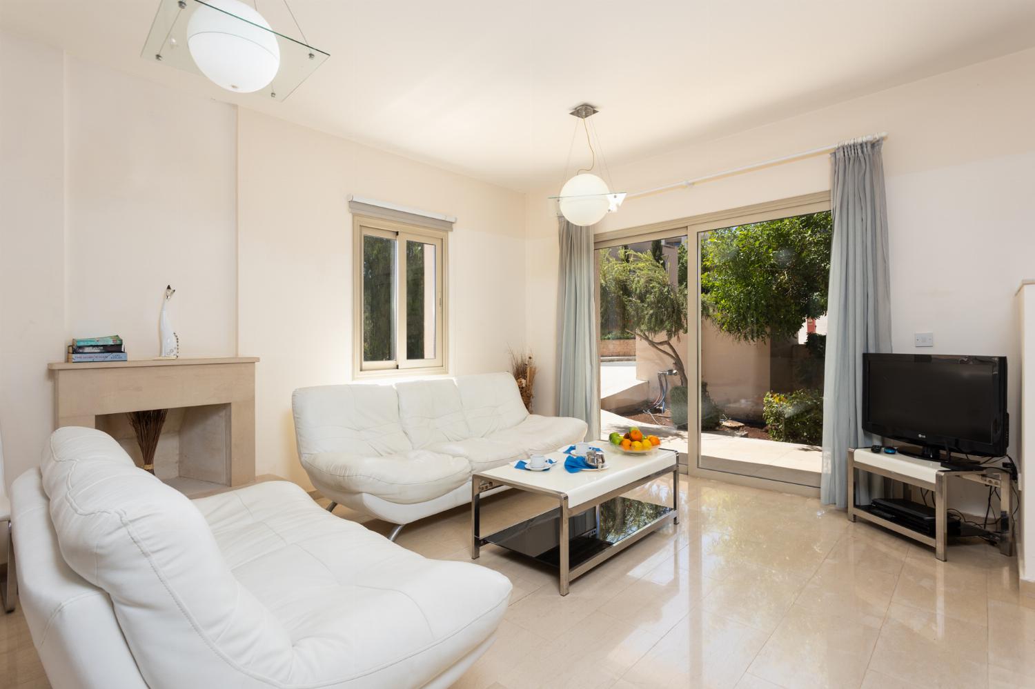 Open-plan living room with sofas, dining area, kitchen, ornamental fireplace, A/C, WiFi internet, and satellite TV