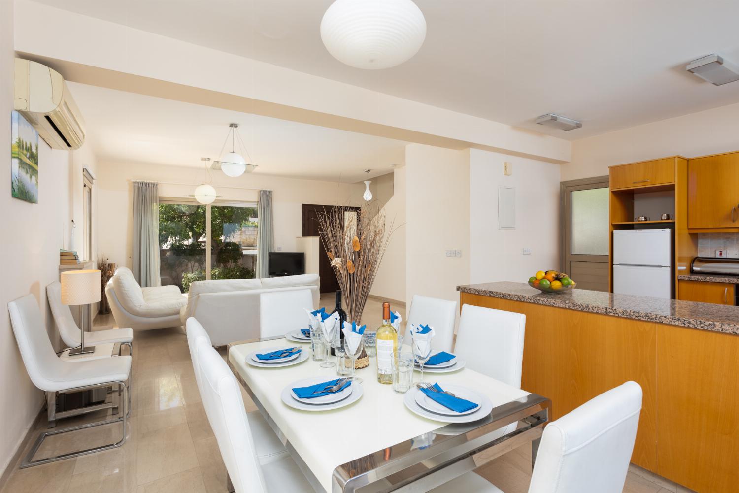Open-plan living room with sofas, dining area, kitchen, ornamental fireplace, A/C, WiFi internet, and satellite TV