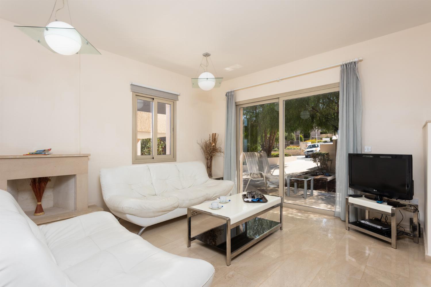 Open-plan living room with sofas, dining area, kitchen, ornamental fireplace, A/C, WiFi internet, and satellite TV