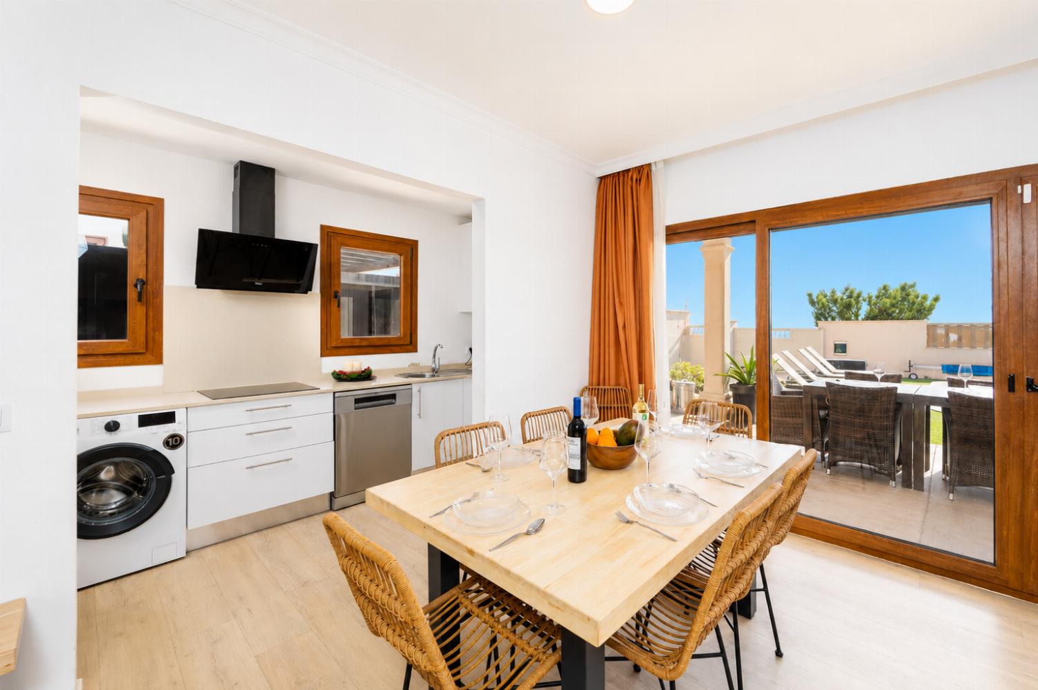 Open-plan living room with sofa, dining area, kitchen, A/C, WiFi internet, and satellite TV