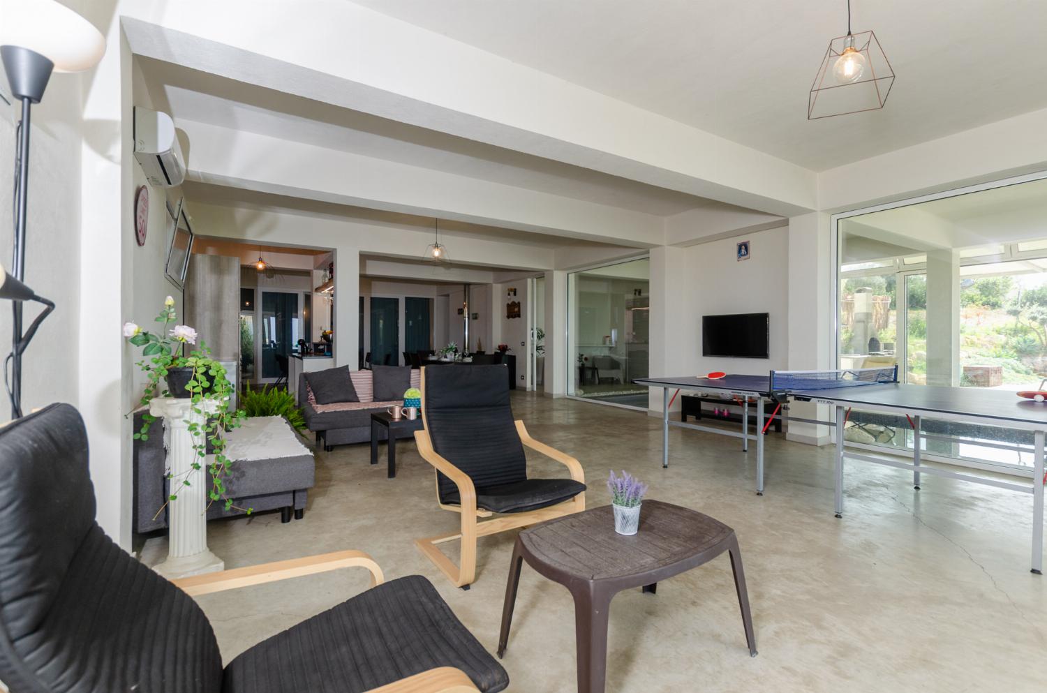 Open plan living room with comfortable sofas, TV, patio doors, AC