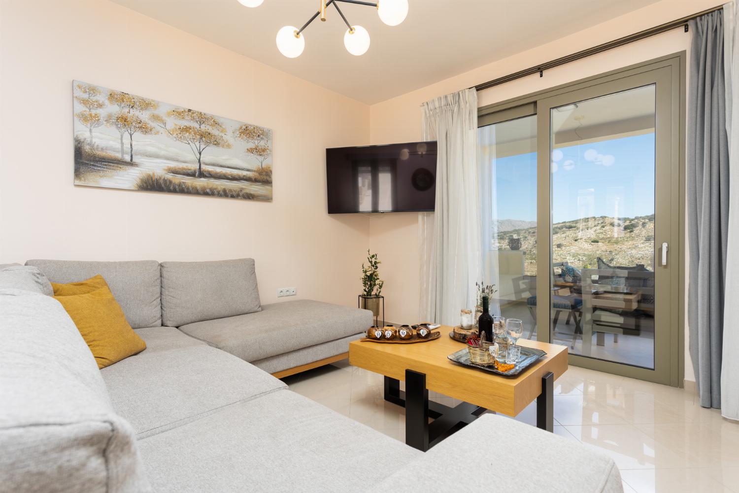 Open-plan living room with sofa, dining area, kitchen, A/C, WiFi internet, and satellite TV