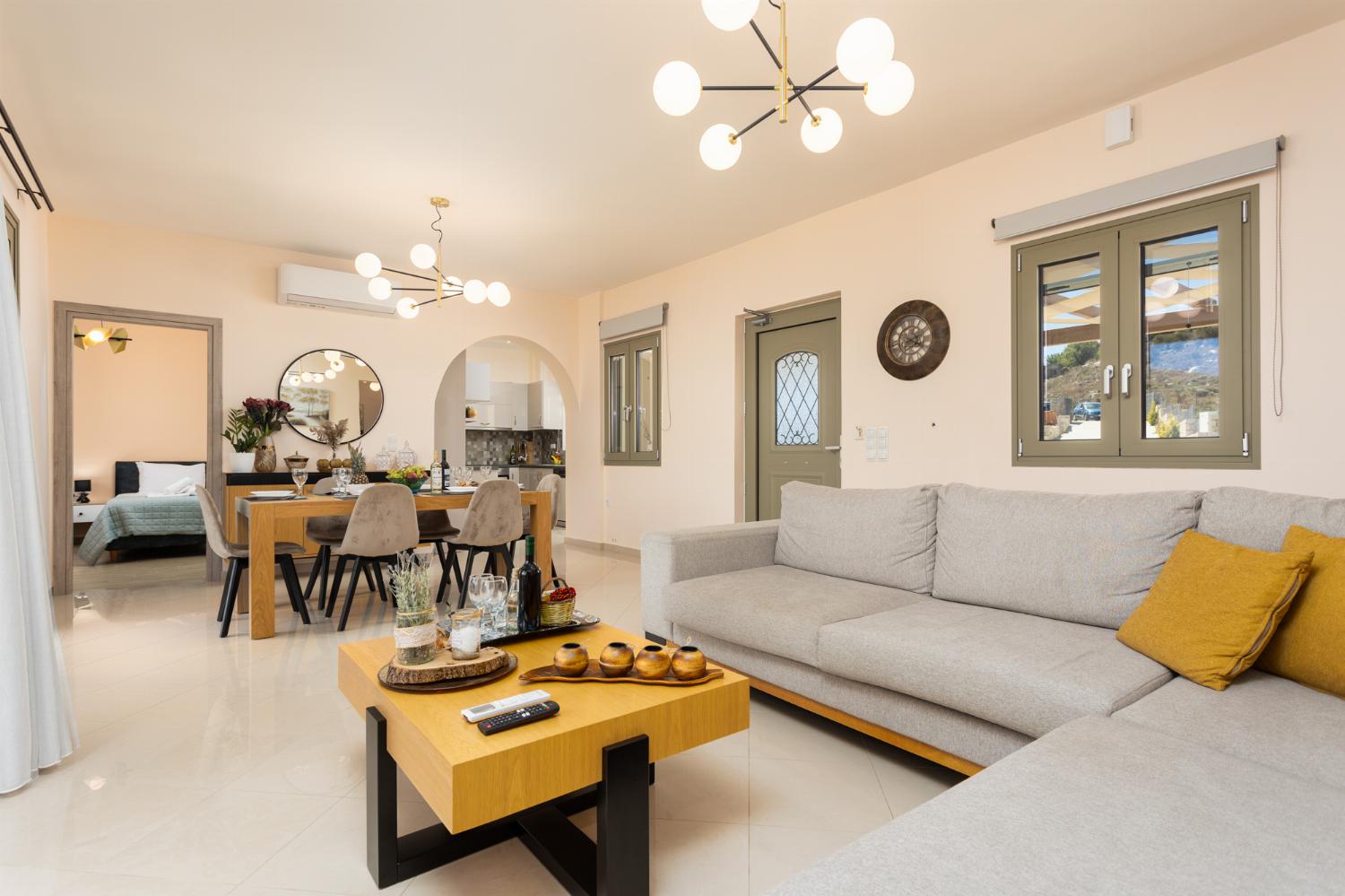 Open-plan living room with sofa, dining area, kitchen, A/C, WiFi internet, and satellite TV