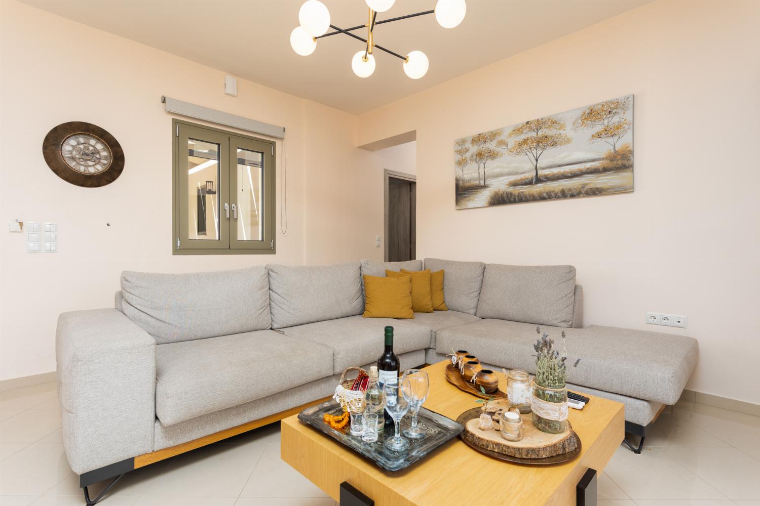 Open-plan living room with sofa, dining area, kitchen, A/C, WiFi internet, and satellite TV