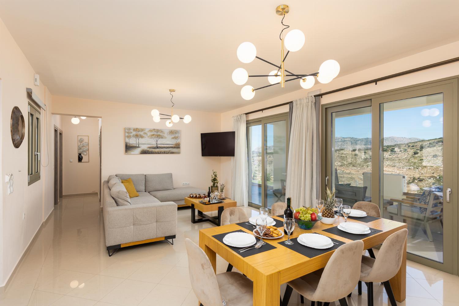 Open-plan living room with sofa, dining area, kitchen, A/C, WiFi internet, and satellite TV