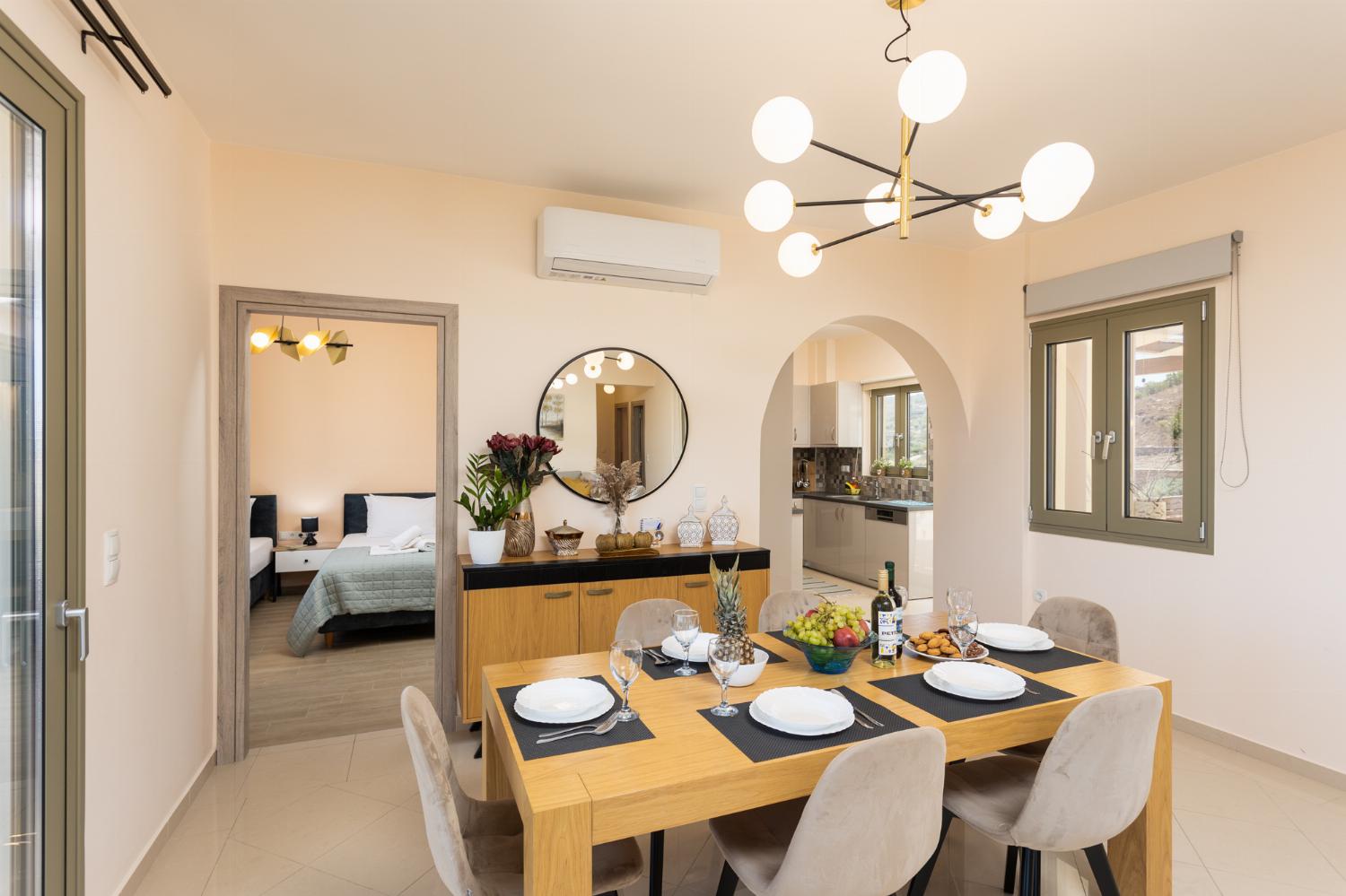 Open-plan living room with sofa, dining area, kitchen, A/C, WiFi internet, and satellite TV