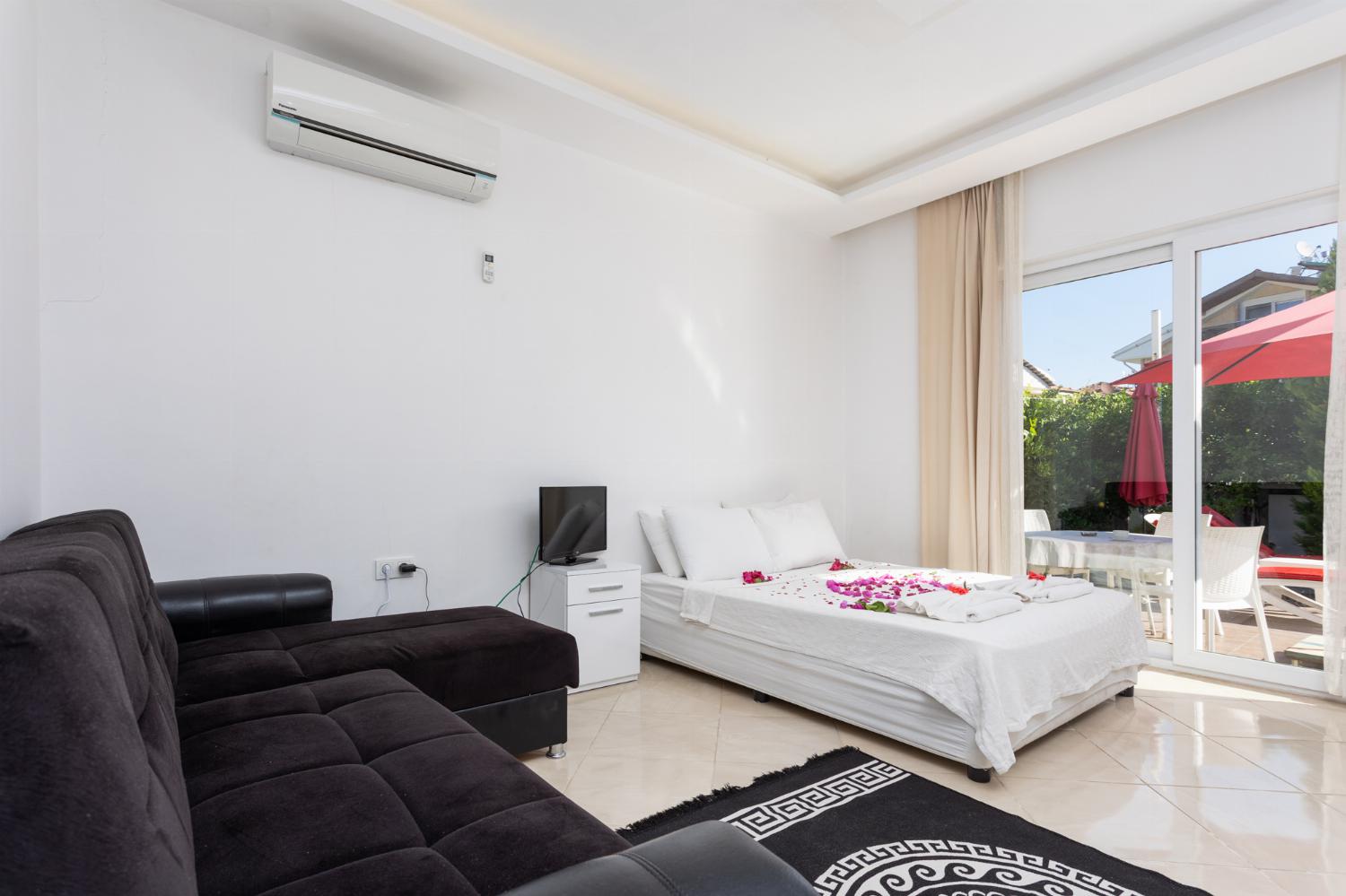 Double bedroom with A/C, kitchenette, sofa, and TV