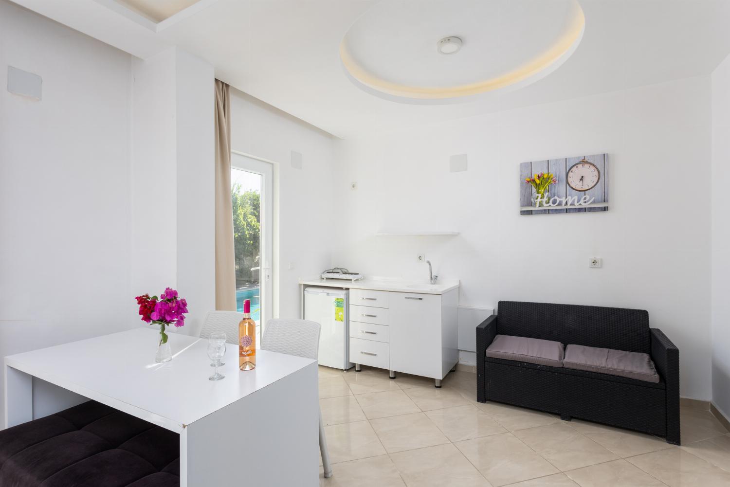 Double bedroom with A/C, kitchenette, sofa, and TV