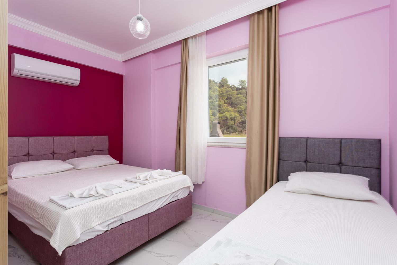 Bedroom with double bed and single bed, and A/C
