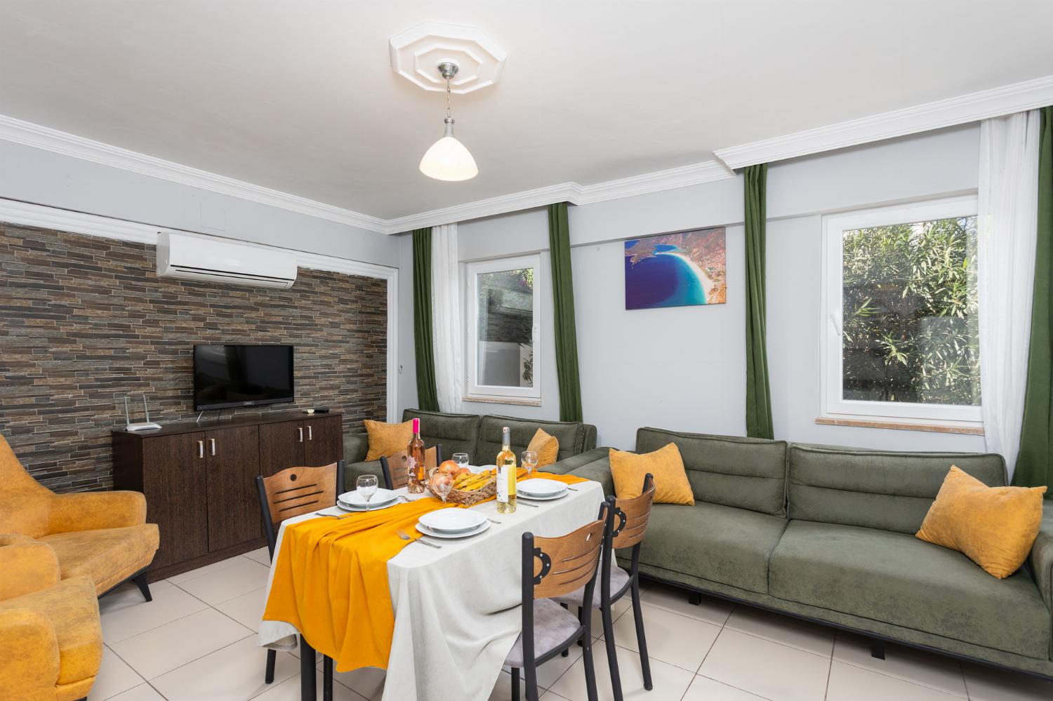 Living room with sofa, dining area, kitchen, A/C, WiFi internet, and satellite TV