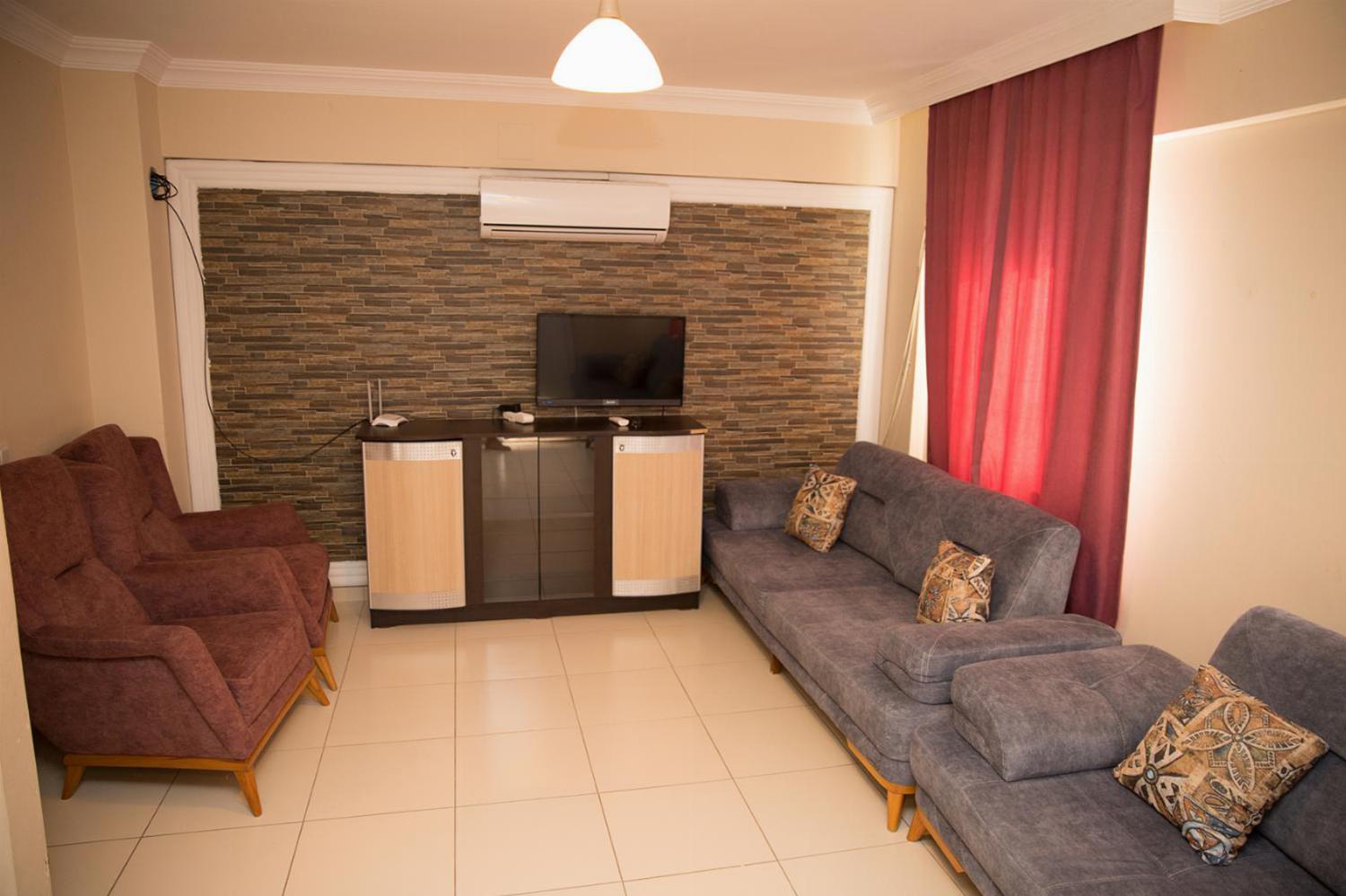 Open-plan living room with sofas, dining area, kitchen, A/C, WiFi internet, satellite TV