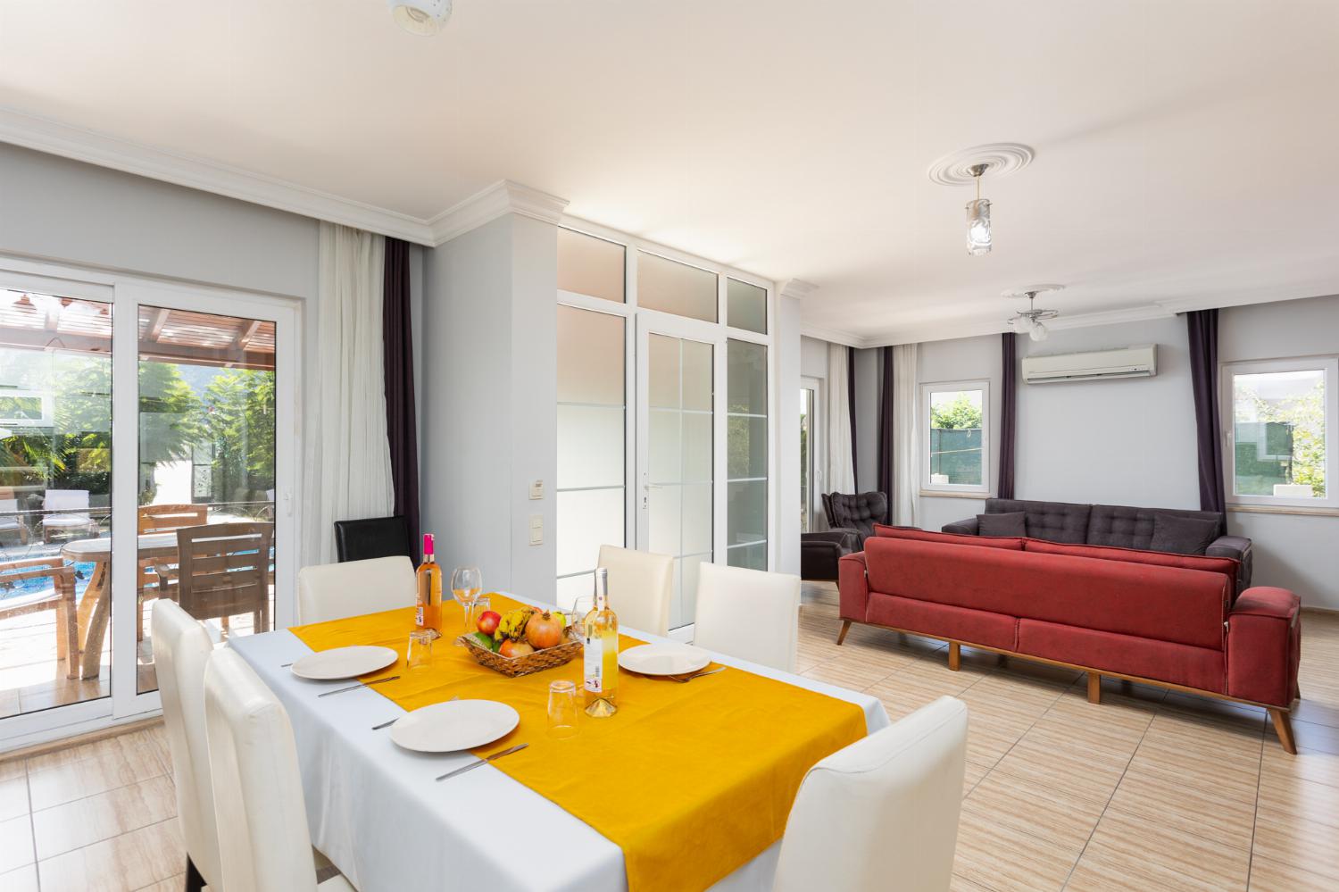 Open-plan living room with sofas, dining area, kitchen, A/C, WiFi internet, and satellite TV