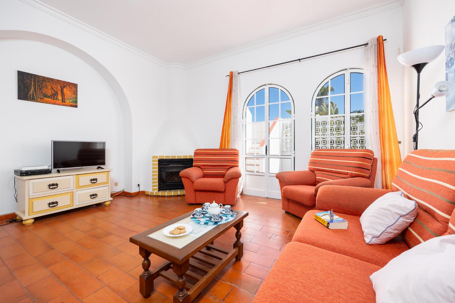 Living room with sofa, dining area, ornamental fireplace, WiFi internet, and satellite TV
