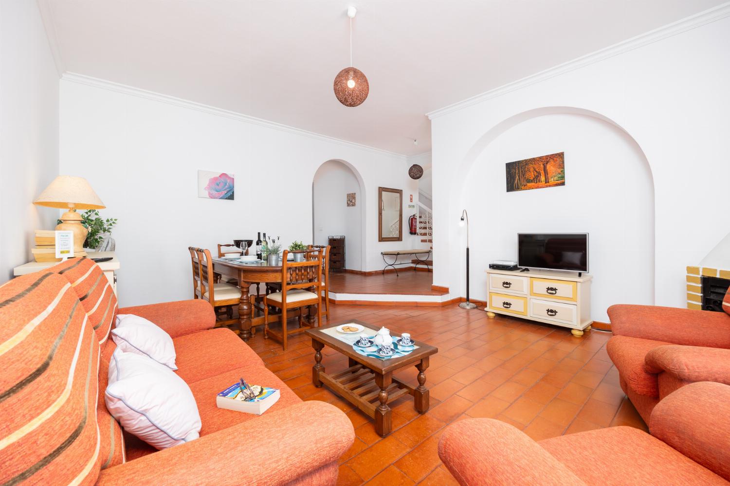 Living room with sofa, dining area, ornamental fireplace, WiFi internet, and satellite TV