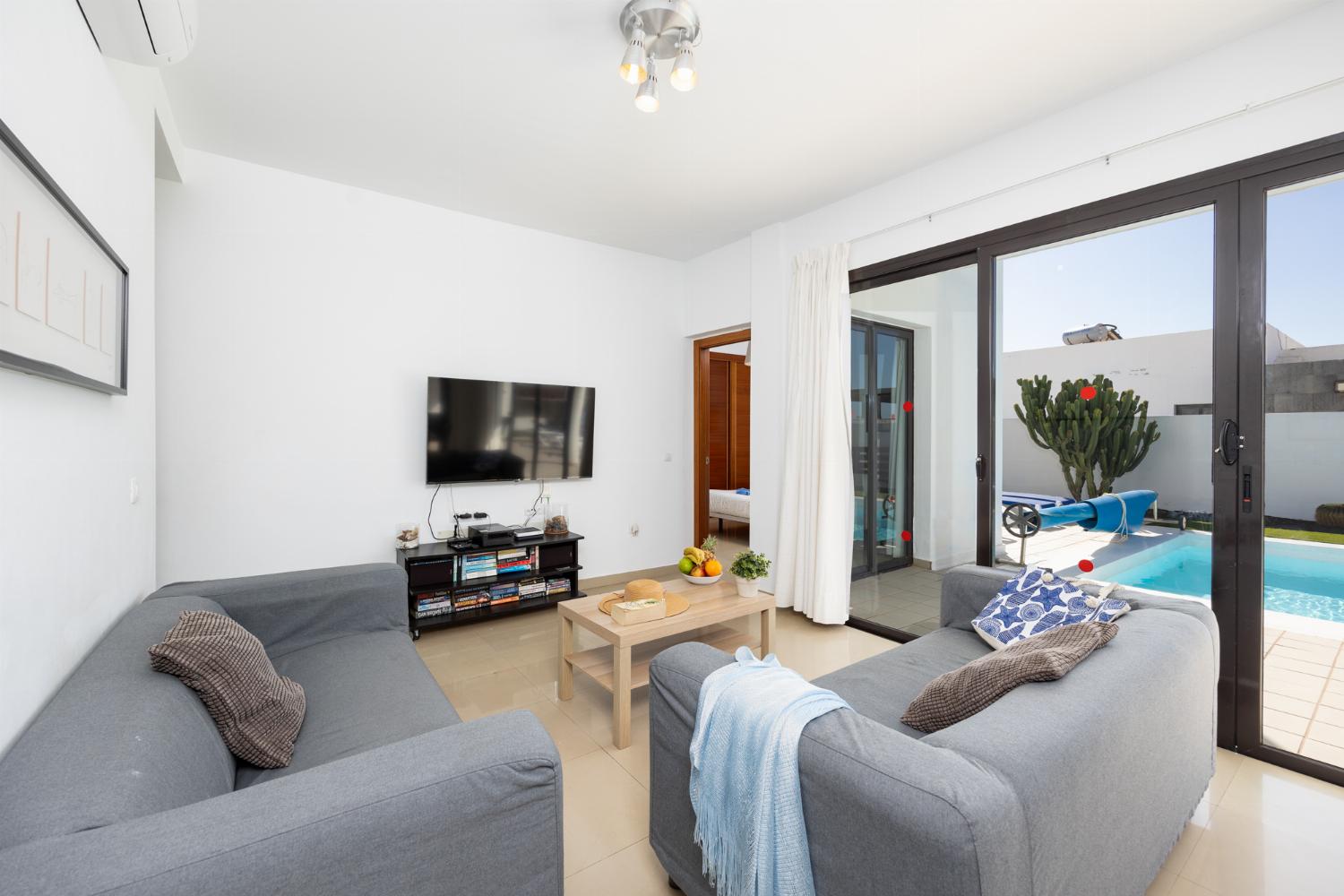 Living room with sofas, dining area, A/C, WiFi internet, and satellite TV