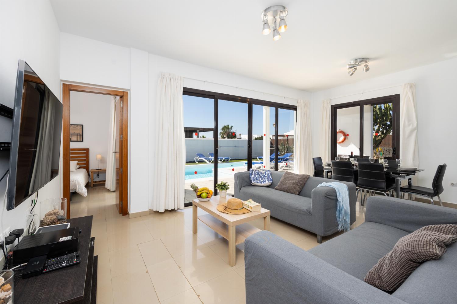 Living room with sofas, dining area, A/C, WiFi internet, and satellite TV