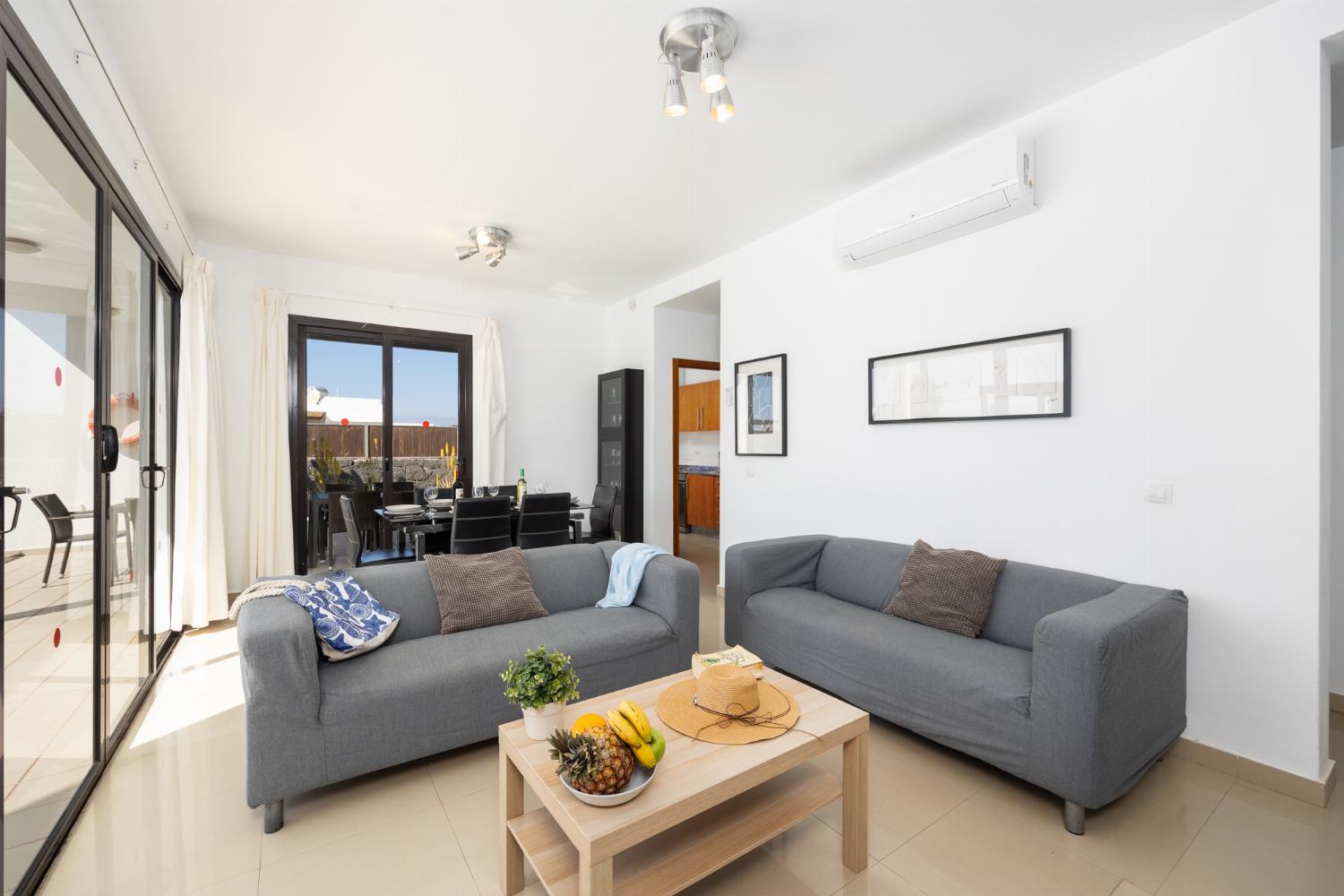 Living room with sofas, dining area, A/C, WiFi internet, and satellite TV