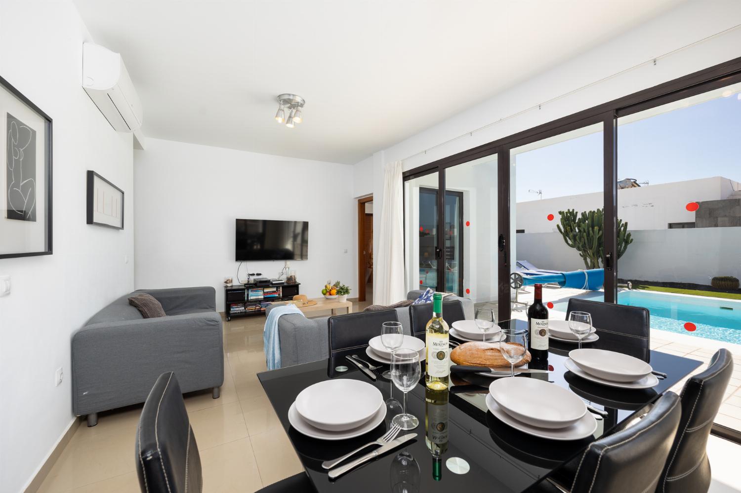 Living room with sofas, dining area, A/C, WiFi internet, and satellite TV