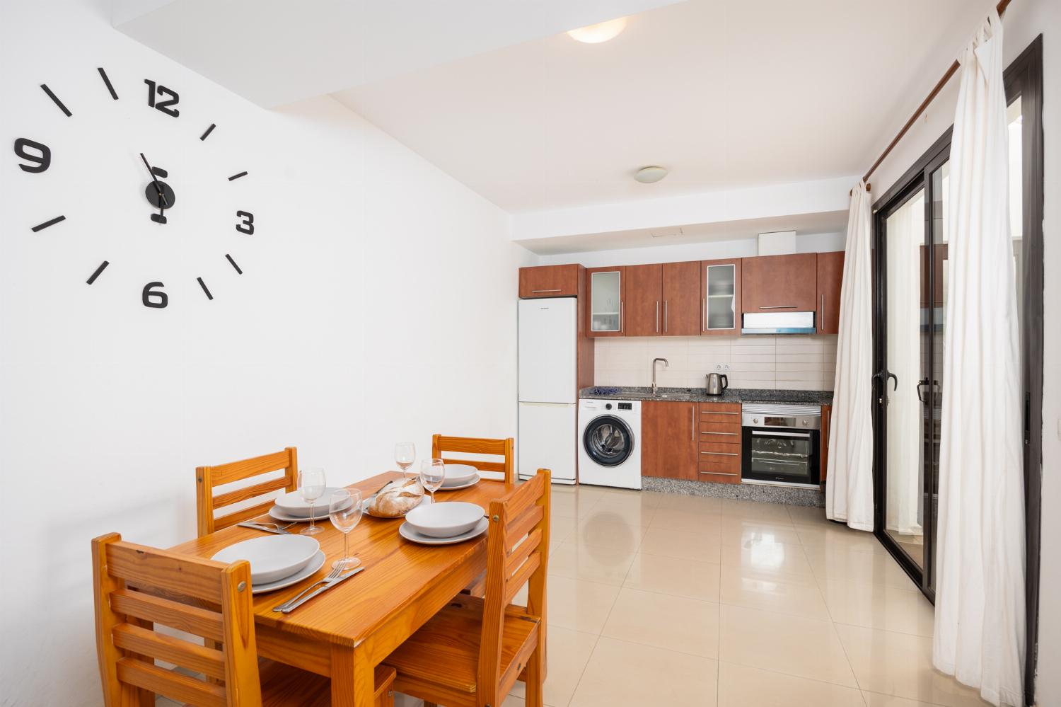 Living room with sofa, dining area, kitchen, and satellite TV