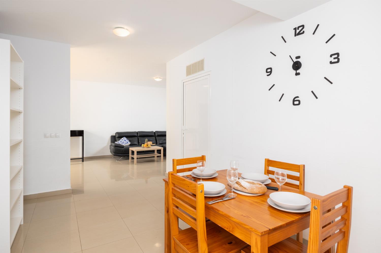 Living room with sofa, dining area, kitchen, and satellite TV