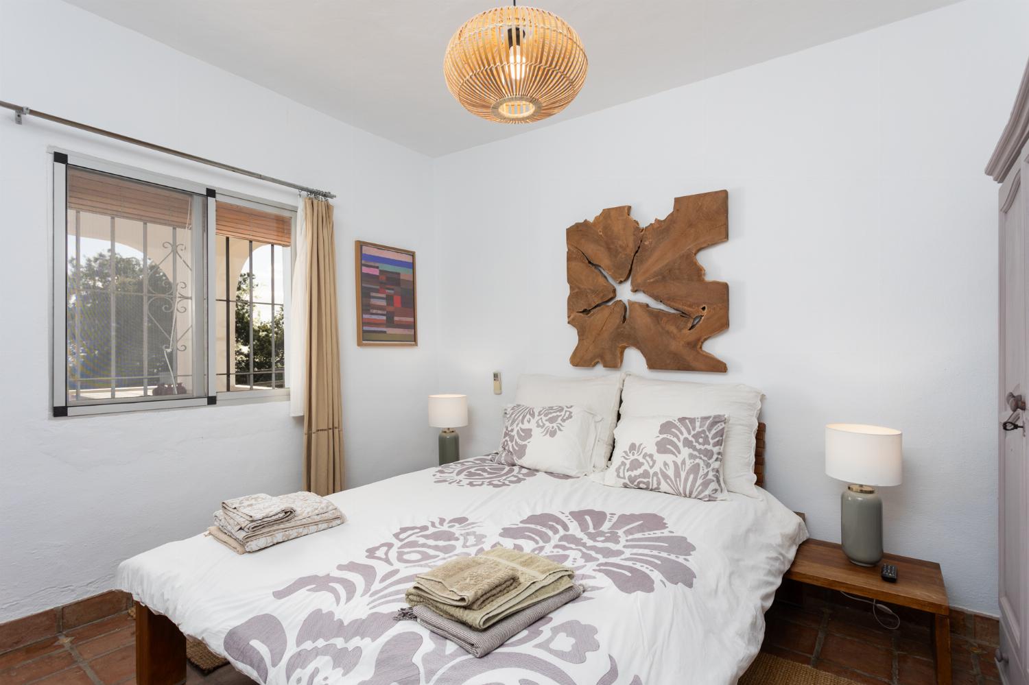 Double bedroom with en suite bathroom, A/C, and TV