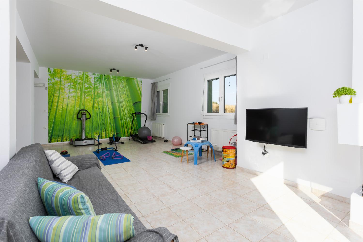 Living area with sofa, gym area, kitchen, and satellite TV