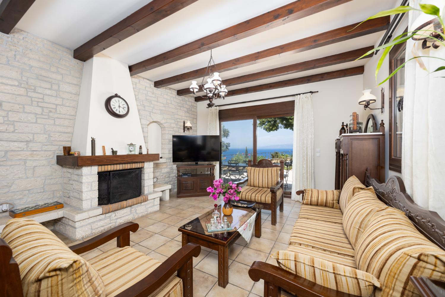 Open-plan living room with sofa, dining area, kitchen, ornamental fireplace, A/C, WiFi internet, satellite TV, and sea views