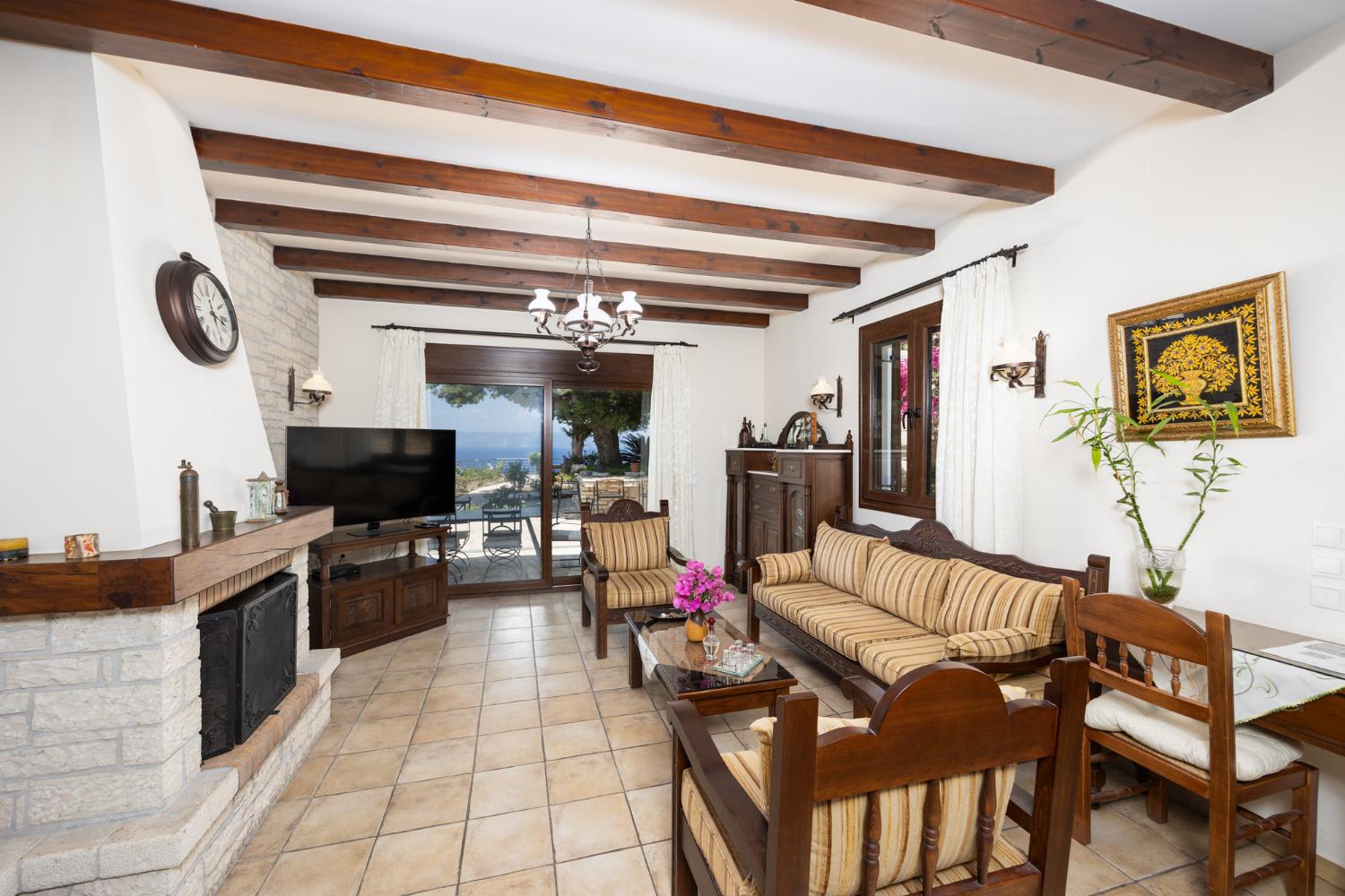 Open-plan living room with sofa, dining area, kitchen, ornamental fireplace, A/C, WiFi internet, satellite TV, and sea views