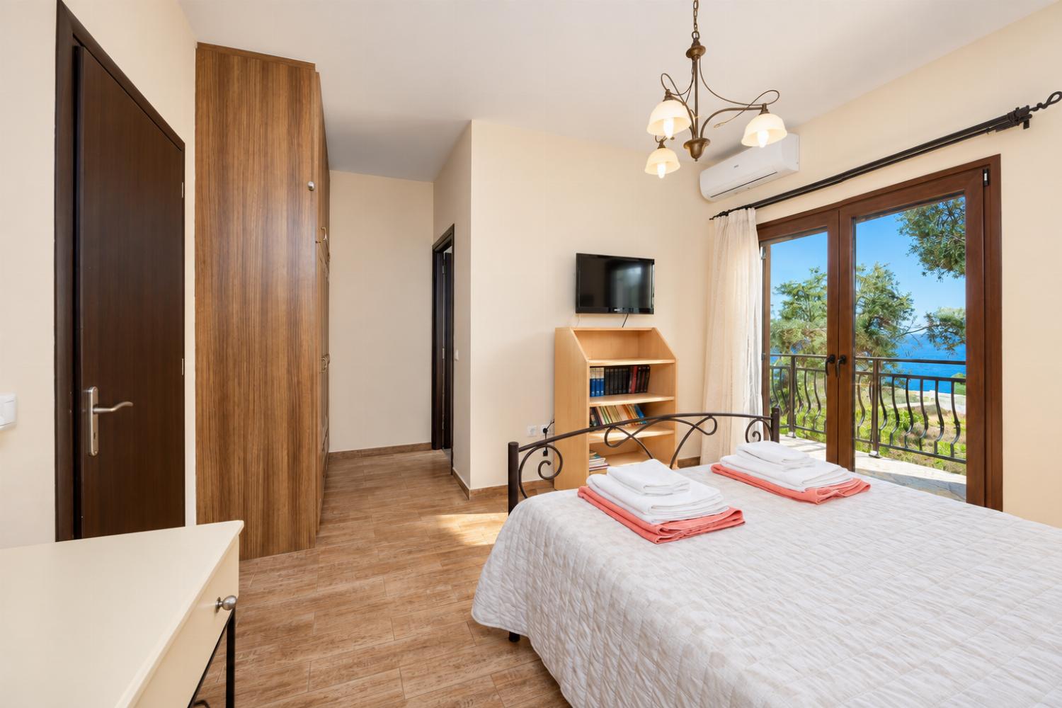Double bedroom with en suite bathroom, A/C, and TV