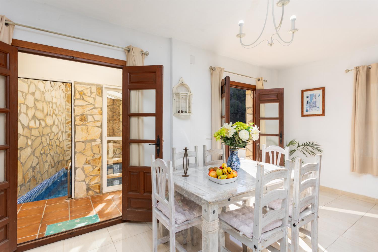 Open-plan living room with sofas, dining area, kitchen, ornamental fireplace, A/C, WiFi internet, and satellite TV