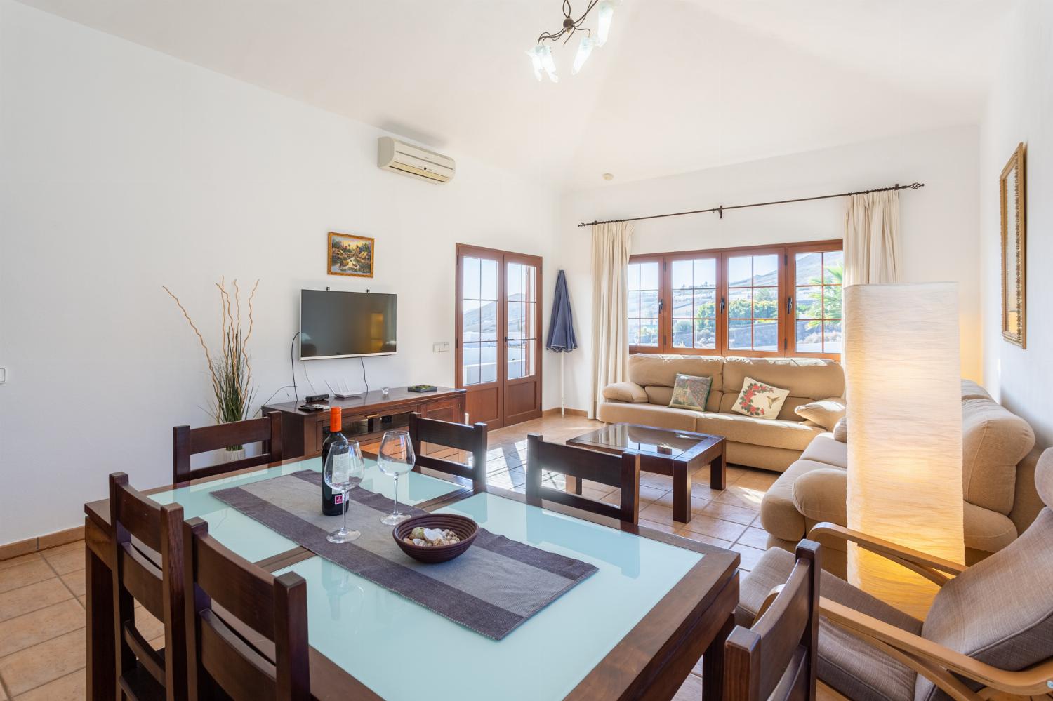 Living room with sofas, dining area, A/C, WiFi internet, and satellite TV