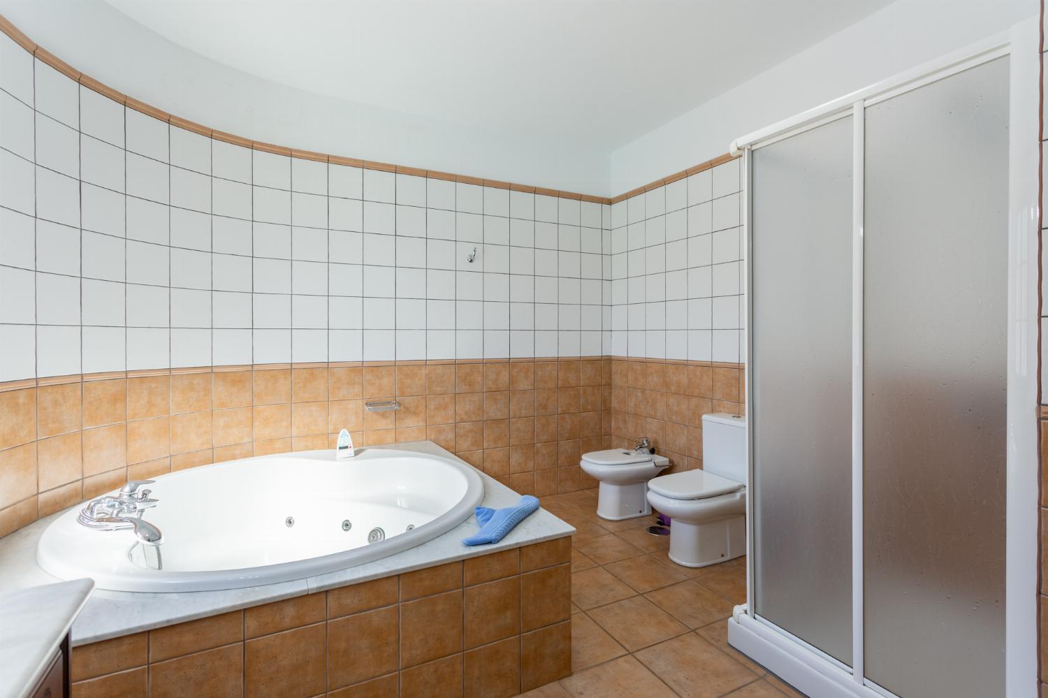 En suite bathroom with jacuzzi and shower