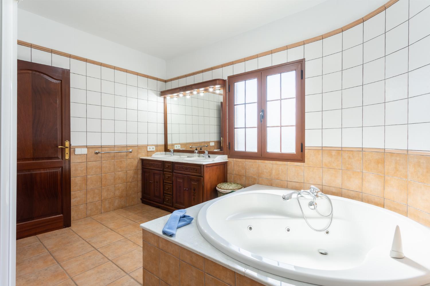 En suite bathroom with jacuzzi and shower