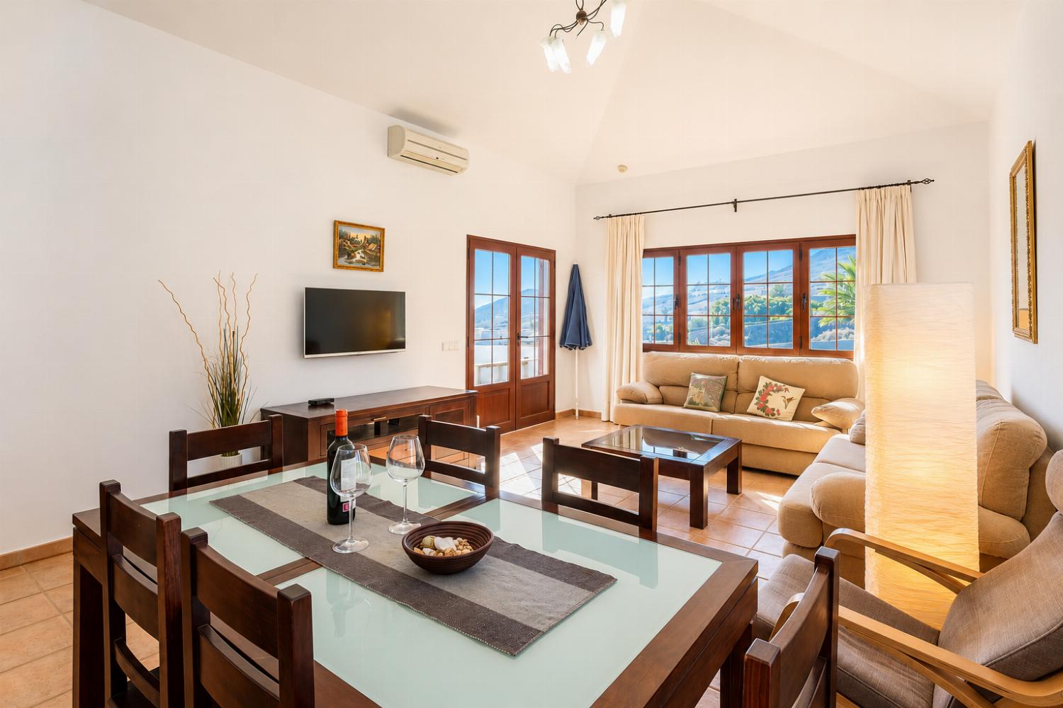 Living room with sofas, dining area, A/C, WiFi internet, and satellite TV