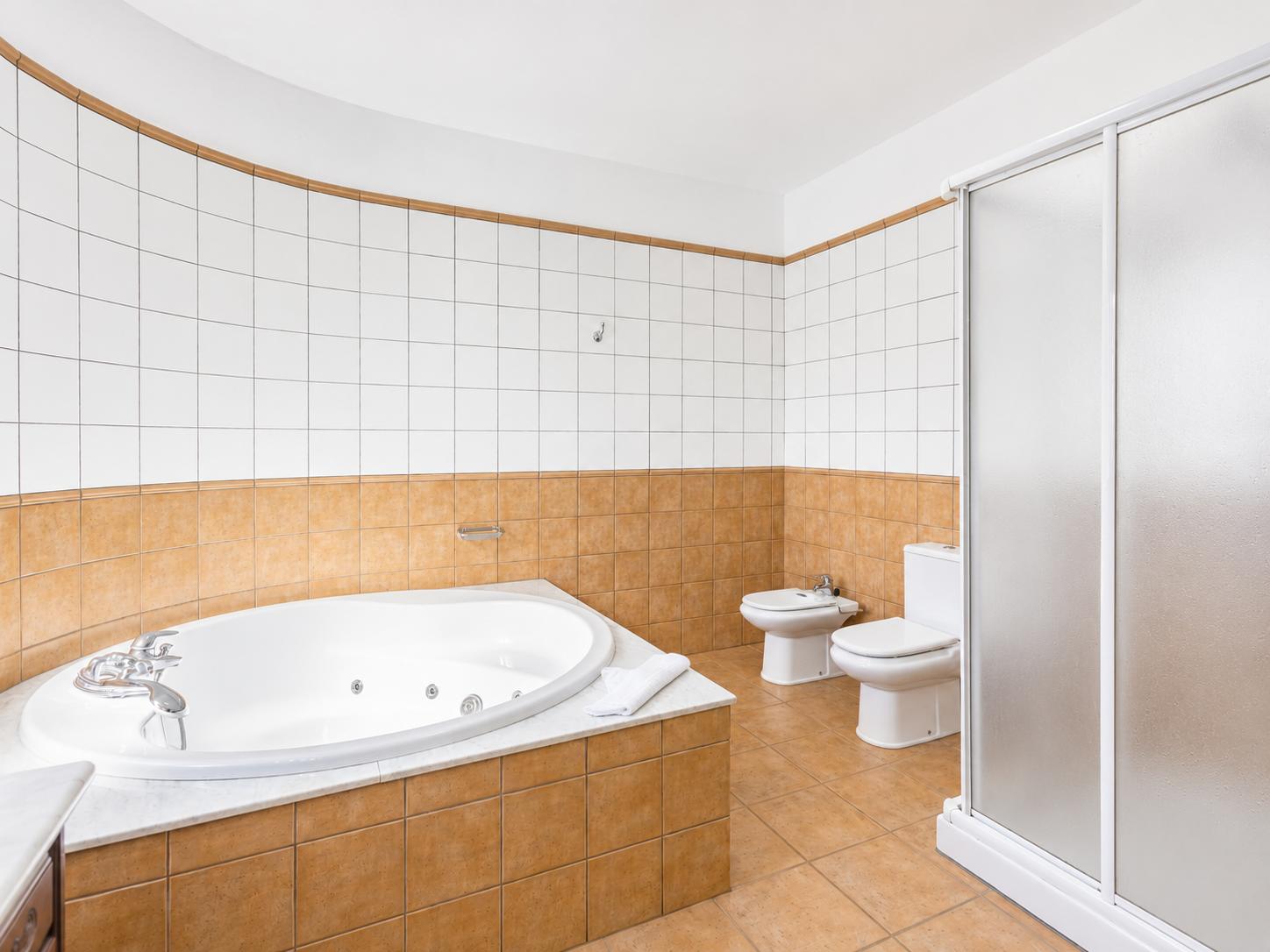 En suite bathroom with jacuzzi and shower