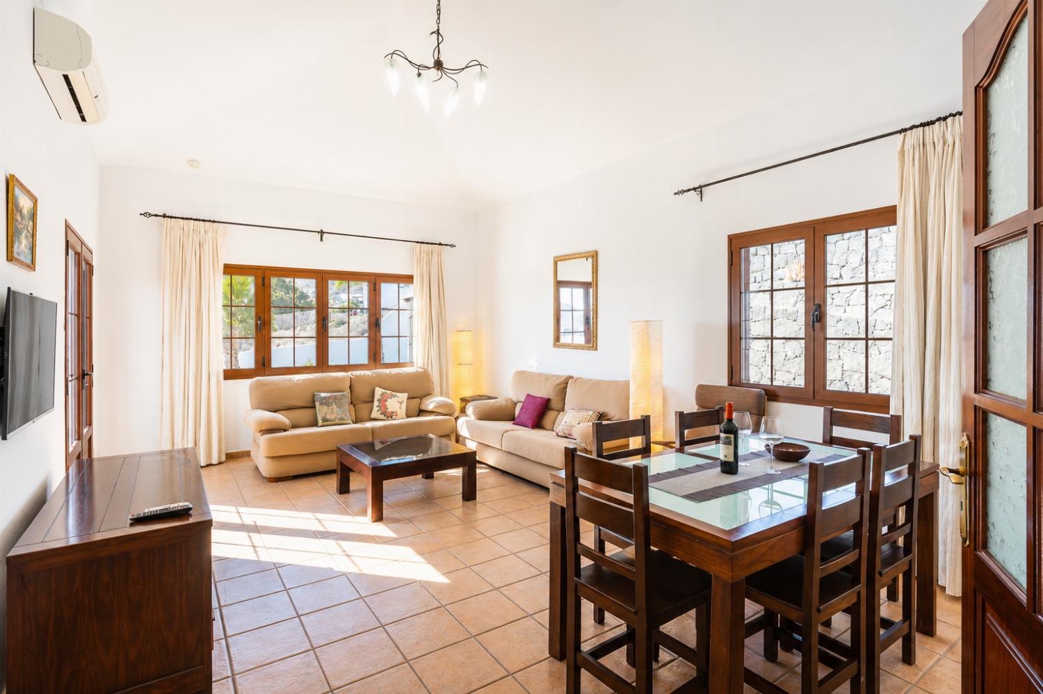 Living room with sofas, dining area, A/C, WiFi internet, and satellite TV