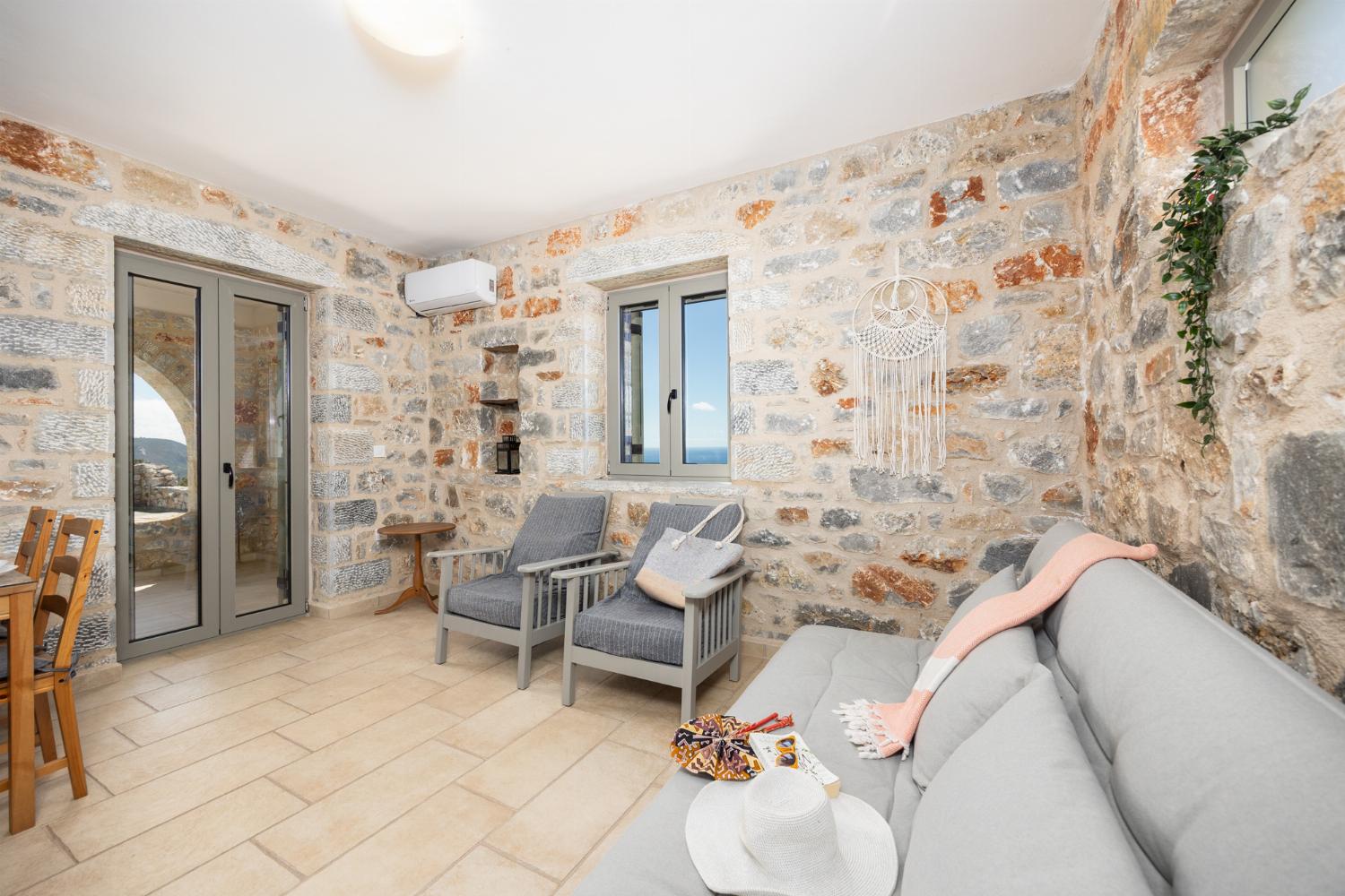 Open-plan living room with sofa, dining area, kitchen, A/C, WiFi internet, and satellite TV